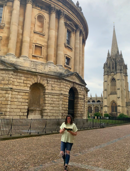 Sarah standing in front of old buildings in Oxford, on a cheap and easy day trip from London