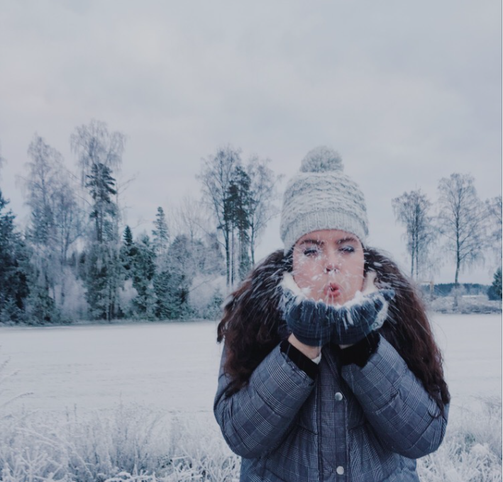 Sarah in front of a background of snowy outdoor scene blowing snow