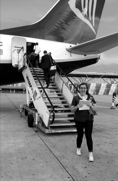 Black and white photo of Sarah on tarmac after exiting a Ryanair plane (behind her)
